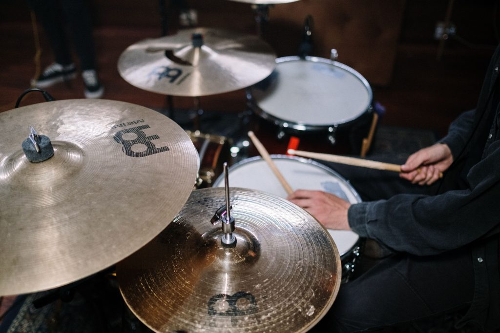 Close-up view of a drummer energetically playing a drum set with focus on cymbals.